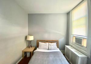 een slaapkamer met een bed en een raam bij Clover 2900 - Apartment and Rooms with Private Bathroom near Washington Ave South Philly in Philadelphia