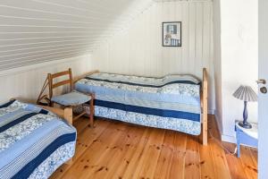 two beds in a room with a wooden floor at Feriehus - Arendal ved sjøen in Arendal