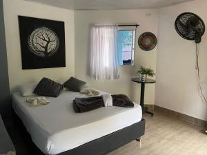 1 cama en un dormitorio con una foto de árbol en la pared en Eco Hostal La Perla Tayrona, en El Zaino