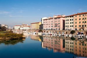 a city with buildings and a river with boats at The Port Residence in Livorno
