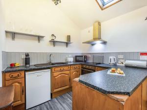 a large kitchen with wooden cabinets and a counter top at 1 Bed in Keswick 86245 in Rosthwaite