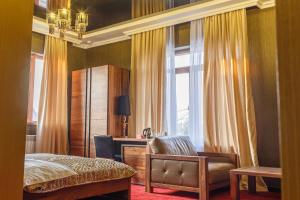 比什凯克Astor Hotel & Spa的一间卧室，里面有一张床、一把椅子和一扇窗户