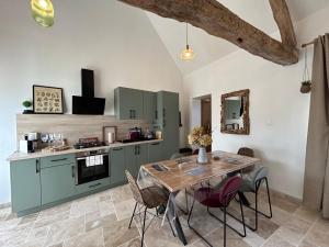 a kitchen with a table and chairs in a room at Le refuge côtier in Rue