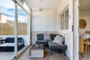 een woonkamer met een bank en een tafel bij Bungalow Aguas Nuevas Sunrise in Torrevieja