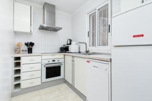 een witte keuken met witte kasten en een koelkast bij Bungalow Aguas Nuevas Sunrise in Torrevieja +19 foto's