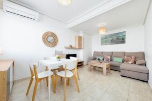 een woonkamer met een tafel en een bank bij Bungalow Aguas Nuevas Sunrise in Torrevieja