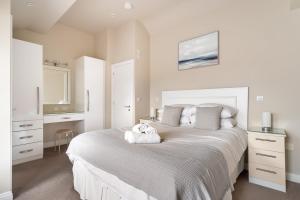 a bedroom with a large white bed and a desk at Ralston in Ambleside