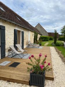 a wooden deck with chairs and flowers in front of a house at CERES HOME in Montierchaume