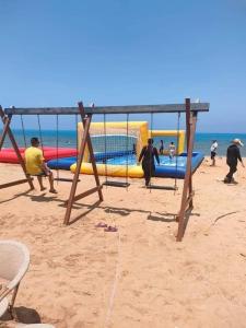 a group of people playing on the beach at Porto South Beach, Sea & Pool View - شاليهات مودرن راقية بورتو ساوث بيتش فيو البحر والبيسين in Ain Sokhna