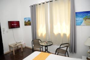 1 dormitorio con mesa, sillas y ventana en Hostal Mi Rincón, en Santo Domingo