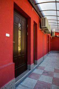un mur rouge avec une porte marron sur un bâtiment dans l'établissement Family Hotel Kipra, à Kipra