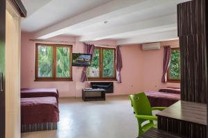 a hotel room with two beds and a television at Family Hotel Kipra in Kipra