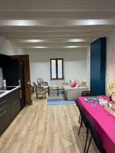 a kitchen and a living room with a pink table at CERES HOME in Montierchaume