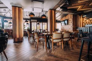 un restaurante con suelo de madera, mesas y sillas en Hotel Aleksandrija, en Ohrid