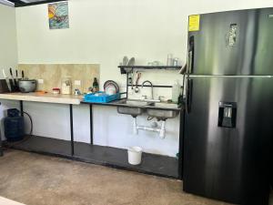 eine Küche mit einem Kühlschrank aus Edelstahl und einer Spüle in der Unterkunft DS House in Cabuya