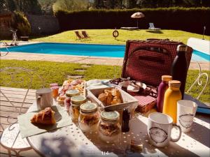 een picknicktafel met eten en drinken erop bij La Roulotte deluxe de Malpas in Quingey