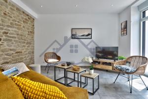 a living room with a couch and a tv at LocaLise - M1 - Bain de mer - Maison entièrement rénové avec jardin clos - Wifi inclus - Draps inclus - Animaux bienvenus in Tréffiagat
