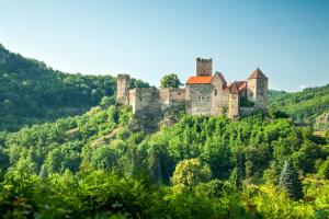 a castle on top of a hill with trees at Gartenapartment Marilyn in Retz