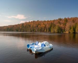 een blauwe en witte boot in het midden van een meer bij Cabines Niksen in Saint Adolphe D'Howard