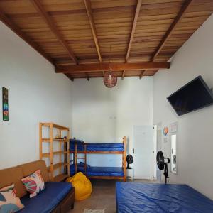 Cette chambre dispose d'un canapé, d'un lit et d'un plafond. dans l'établissement A VER O MAR FLATS, à Caraguatatuba