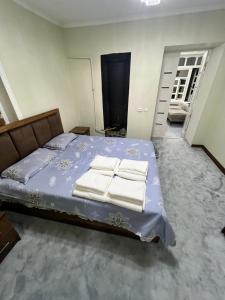 a bedroom with a bed with towels on it at STS-Family home guest house in Samarkand