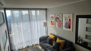 a living room with a couch and a large window at Best Apartment Rental Estación Central in Santiago