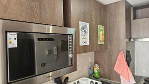 a kitchen with a large flat screen tv on a wall at Best Apartment Rental Estación Central in Santiago