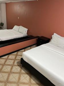 duas camas num quarto de hotel com lençóis brancos em Way Maker 1 em Bogotá