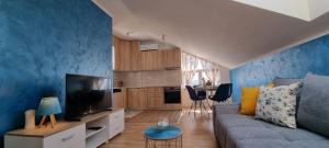 a living room with a couch and a tv at Nakiiii apartmanii in Podgorica