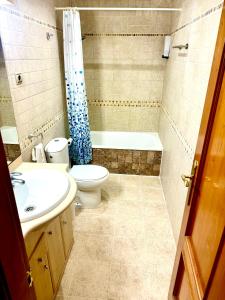 La salle de bains est pourvue de toilettes, d'un lavabo et d'une baignoire. dans l'établissement Cozy Fuengirola apartment with sea view & pool, à Fuengirola