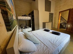 1 dormitorio con 1 cama con 2 almohadas en The Nest 148 Townhouse, en Għajn il-Kbira