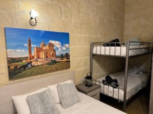 1 dormitorio con literas y una pintura de un castillo en The Nest 148 Townhouse, en Għajn il-Kbira
