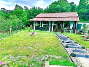 a garden with a building with a pathway in the grass at El nido del cuco in Padrón