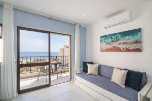 a living room with a couch and a view of the ocean at Cruzeiro - Silhueta Citadina in Portimão