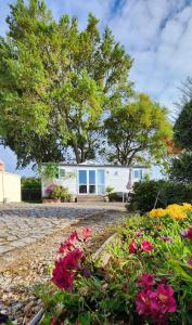 una casa blanca con flores delante en Casa Floravista en Bombarral