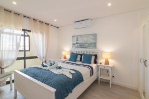 um quarto com uma cama grande e almofadas azuis em Cruzeiro - Silhueta Citadina em Portimão