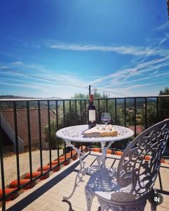 a table with a bottle of wine on a balcony at Casa do Avô Xico in Sabugal