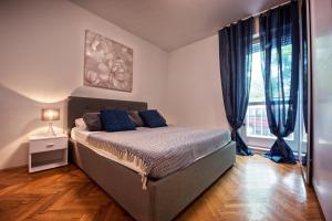a bedroom with a bed with blue pillows on it at Apartment Pape in Split