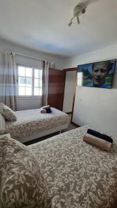 Una habitación de hotel con dos camas y una pantalla grande. en Villa Pousadoiro, en Playa Blanca 58 fotos más
