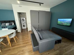 sala de estar con sofá y TV en la pared en Capital Heights Suite, Victoria en Victoria