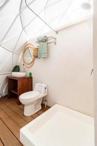 uma casa de banho branca com um WC e um lavatório em Ubuntu Glamping em Guanacaste