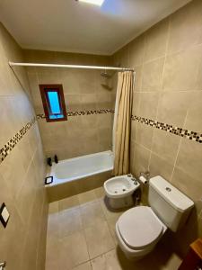 een badkamer met een toilet en een bad bij Bosques de ñires in Ushuaia