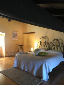 a bedroom with a large bed with a white blanket at La Casa di Helena in Stroncone