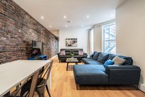 a living room with a blue couch and a brick wall at Ideal Group Stay in Charming Le Plateau Near Metro in Montreal
