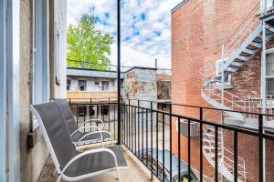 une chaise assise sur un balcon avec un bâtiment dans l'établissement Ideal Group Stay in Charming Le Plateau Near Metro, à Montréal