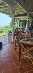 - une terrasse couverte avec des chaises et une table dans l'établissement Beausejour Guest House, à Pointe-Noire