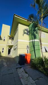 a building with a palm tree and a trash can at GH Canal da Barra in Florianópolis