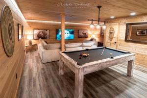a room with a pool table in a cabin at Chalet Makabane -Spa- foyer - billard - Slow life in La Malbaie