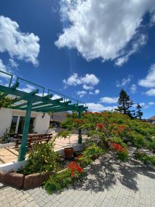 einem grünen Pavillon mit Blumen vor einem Gebäude in der Unterkunft VILLA VEGUETA in La Vegueta
