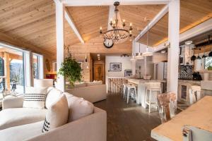 a living room and kitchen with a couch and a table at Chalet Makabane -Spa- foyer - billard - Slow life in La Malbaie